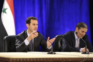 Syria's President Bashar al-Assad (L) meets with professors and students of political science college in Damascus, in this handout photograph released by Syria's national news agency SANA