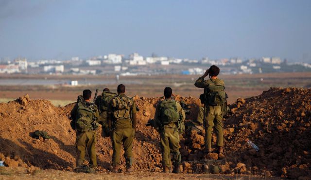 Israeli soldiers look toward the Gaza Strip