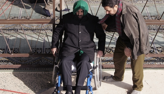 A man helps a veteran of the war between Iraq and Iran during Friday prayers in Tehran