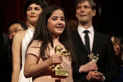 Hana Saeidi, niece of absent Iranian Director Jafar Panahi, holds the Golden Bear for the best Film for 'Taxi' she received on his behalf during the award ceremony at the 2015 Berlinale Film Festival in Berlin, Germany, Saturday, Feb. 14, 2015. (AP Photo/Michael Sohn)