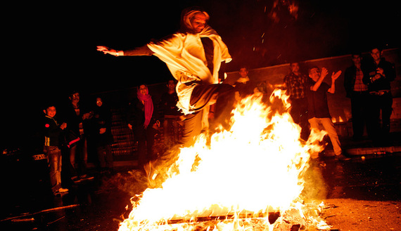 An Iranian woman jumps over a bonfire in southern Tehran on March 19, 2013, during the Wednesday Fire feast, or Chaharshanbe Suri. (photo by BEHROUZ MEHRI/AFP/Getty Images)