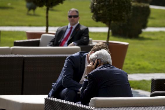 U.S. Secretary of State John Kerry (front) talks on the phone while waiting for lunch following a morning meeting with Iran's Foreign Minister Mohammad Javad Zarif over Iran's nuclear programme in Lausanne March 19, 2015. REUTERS/Brian Snyder
