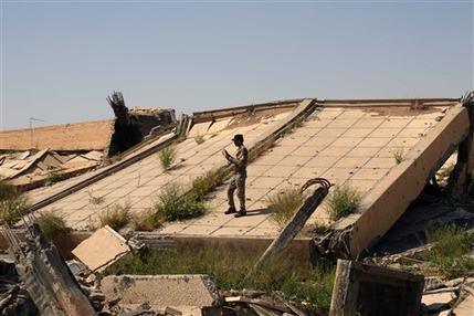 An Iraqi soldier takes photos of the demolished tomb of former Iraqi president, Saddam Hussein, in Tikrit, 130 kilometers (80 miles) north of Baghdad, Iraq, Sunday, March 15, 2015. (AP Photo/Khalid Mohammed)